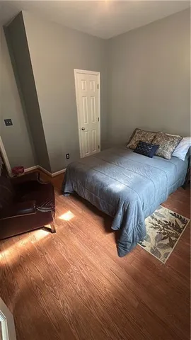 a bedroom with a bed and wooden floor
