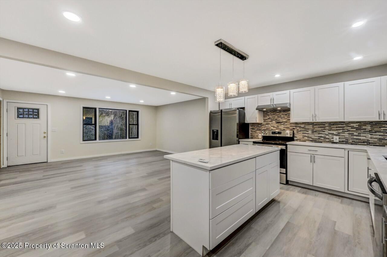 71 Sandy Beach Road Gouldsboro, PA 18424 - Photo 19 of 57 a kitchen with stainless steel appliances granite countertop a white cabinets and wooden floor