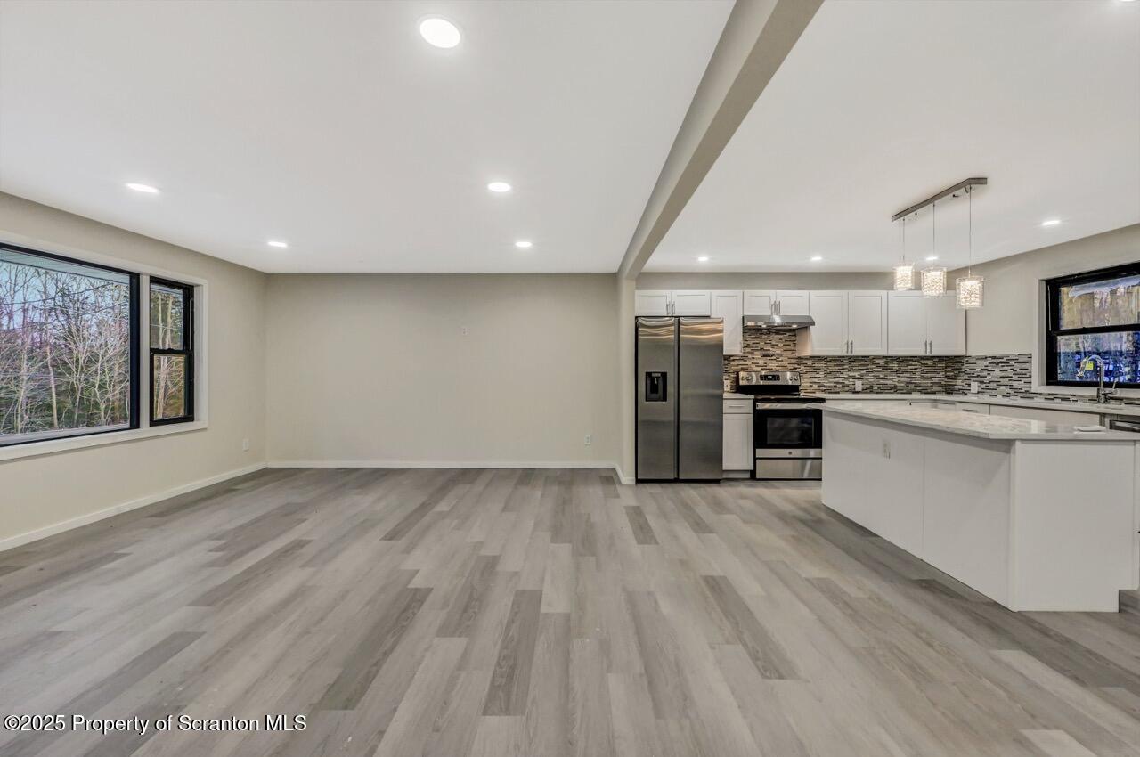 71 Sandy Beach Road Gouldsboro, PA 18424 - Photo 27 of 57 a large kitchen with stainless steel appliances kitchen island a large counter top and a stove top oven