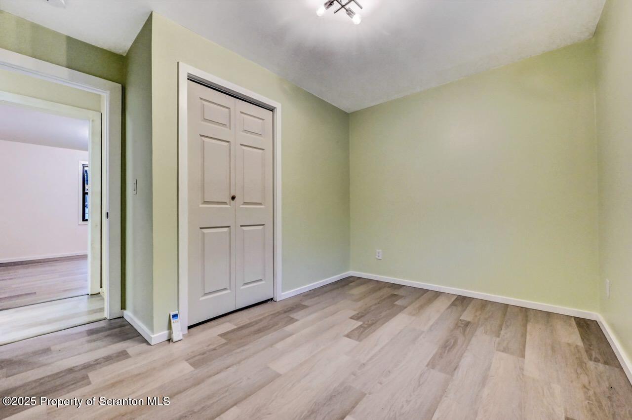 71 Sandy Beach Road Gouldsboro, PA 18424 - Photo 39 of 57 an empty room with wooden floor and mirror