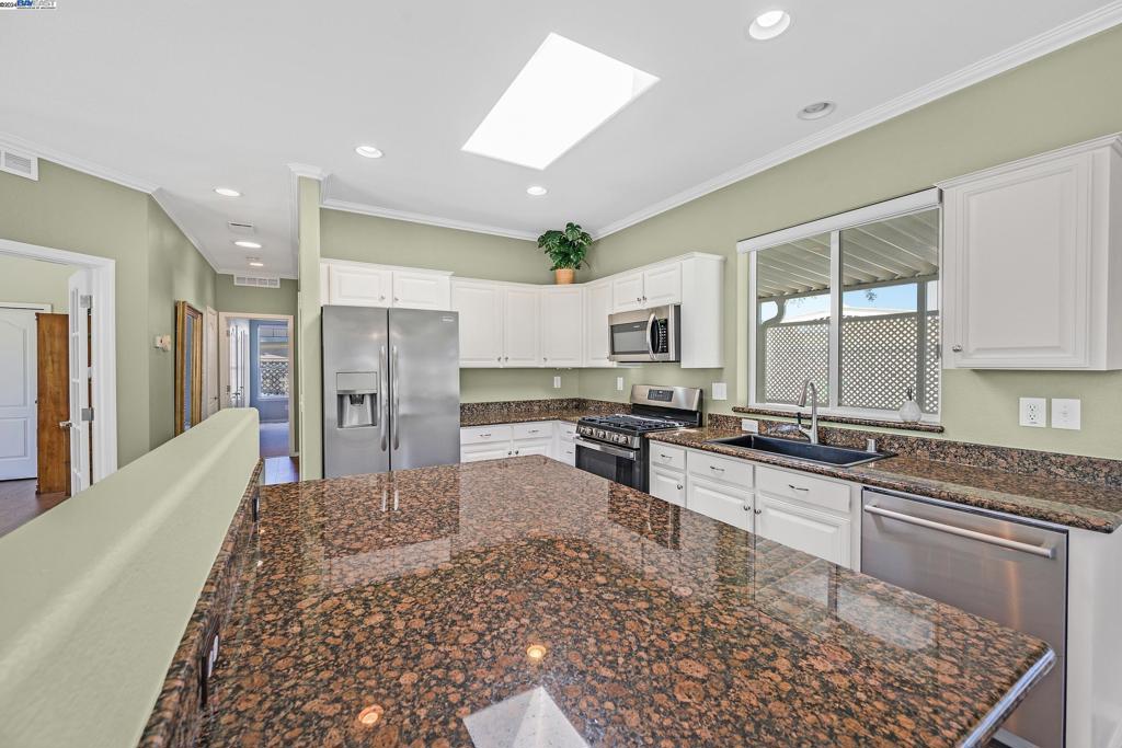 3263 Vineyard Avenue Pleasanton, CA 94566 - Photo 3 of 14 a large kitchen with stainless steel appliances kitchen island granite countertop a refrigerator and a stove top oven