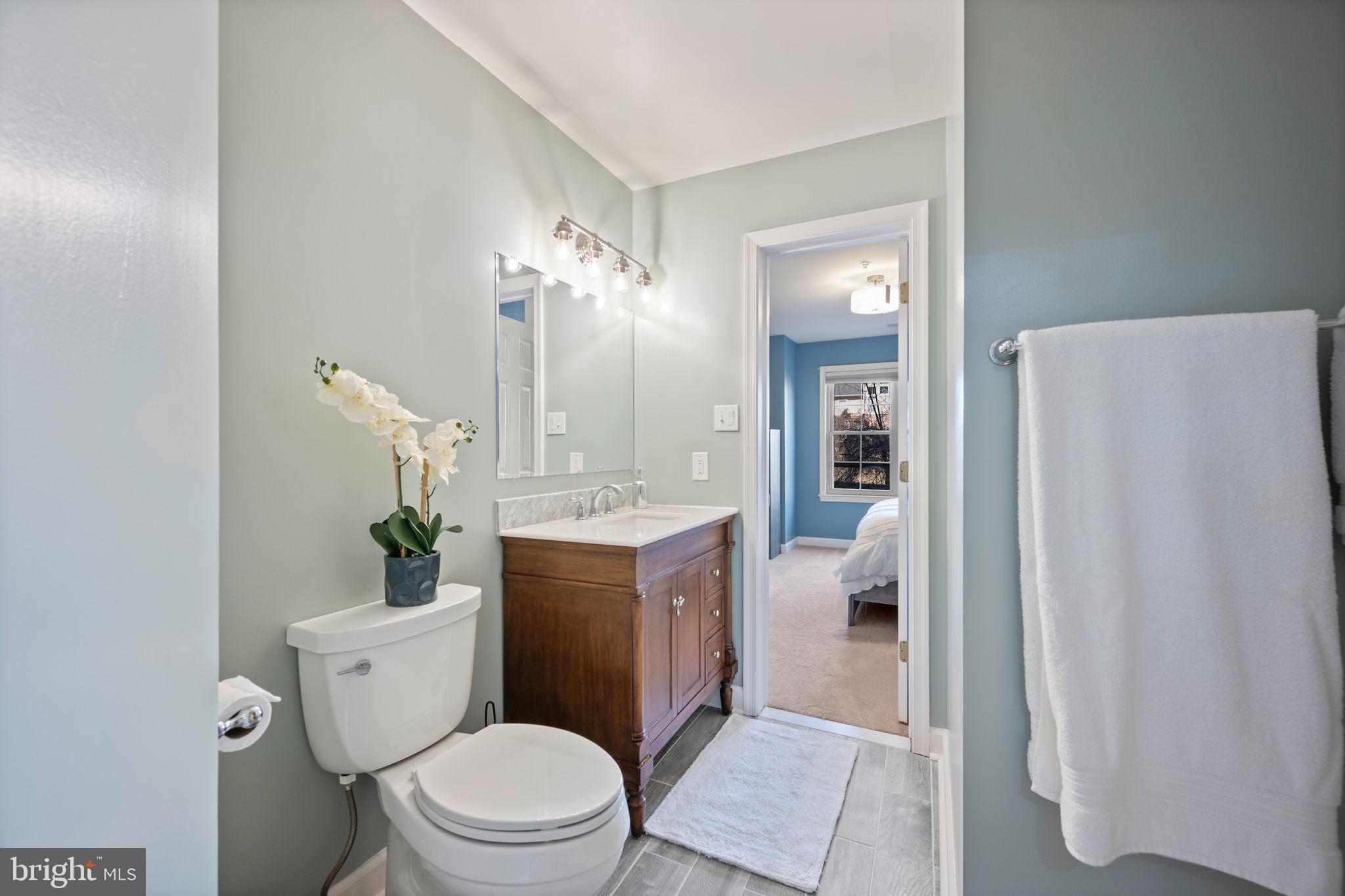 2322 Falls Gable Lane, Unit N Baltimore, MD 21209 - Photo 27 of 44 a bathroom with a granite countertop toilet a sink and a mirror
