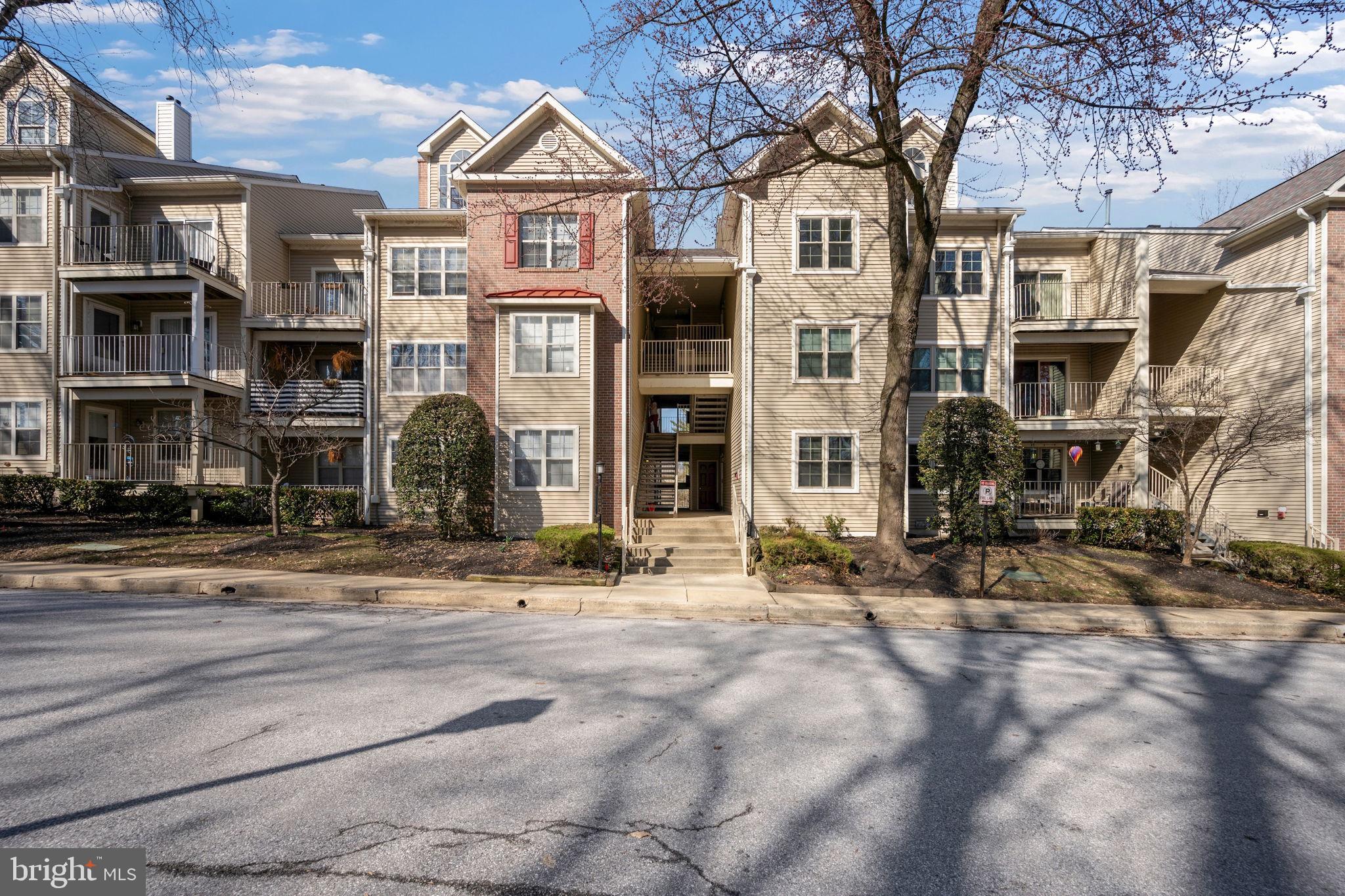 2322 Falls Gable Lane, Unit N Baltimore, MD 21209 - Photo 36 of 44 a front view of a residential apartment building with a yard