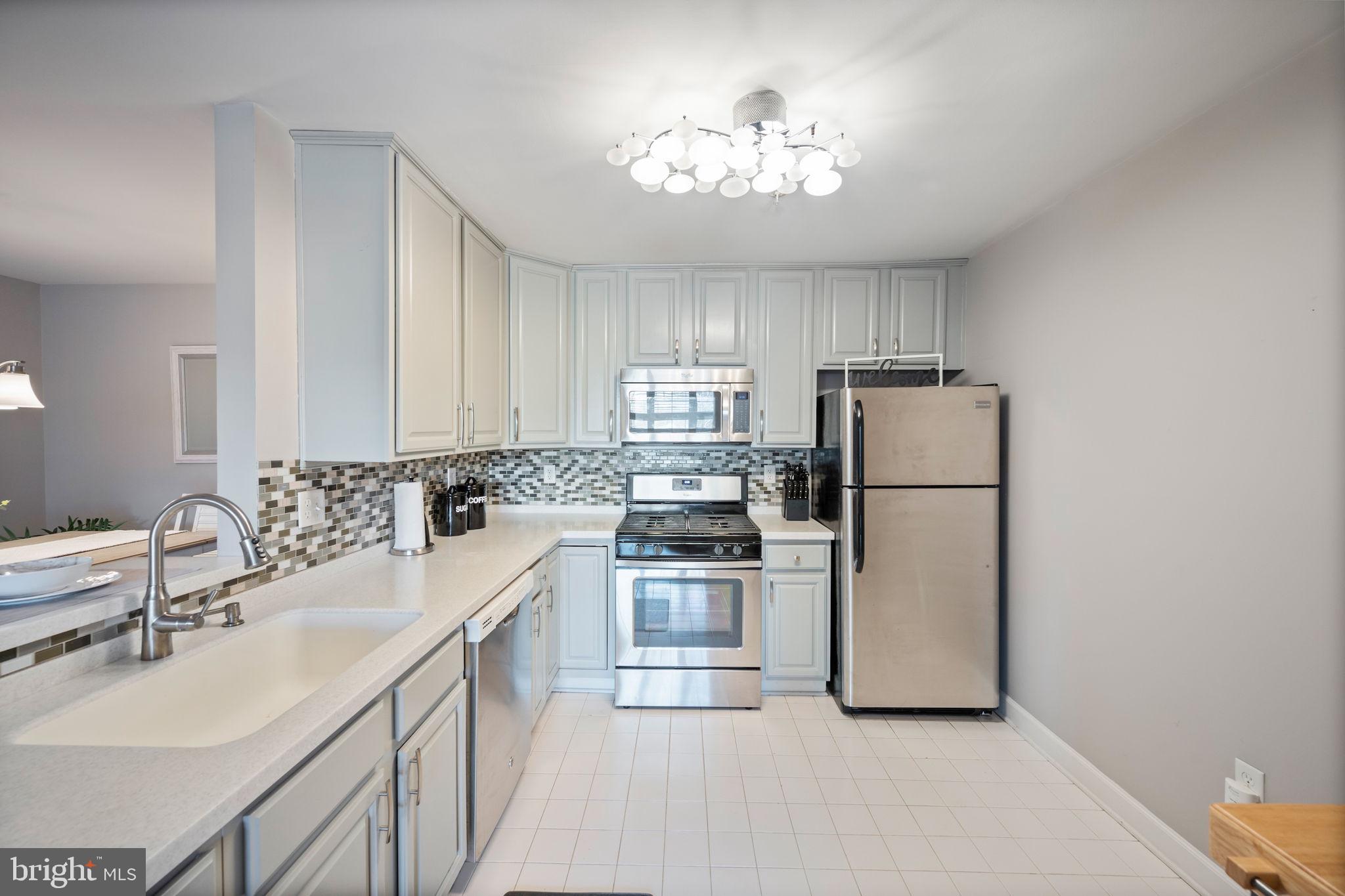 2322 Falls Gable Lane, Unit N Baltimore, MD 21209 - Photo 8 of 44 a kitchen with a sink stainless steel appliances and chandelier