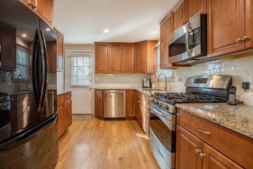 1 Spring Lane Sharon, MA 02067 - Photo 4 of 23 a kitchen with stainless steel appliances granite countertop a stove a sink dishwasher a refrigerator and cabinets with wooden floor