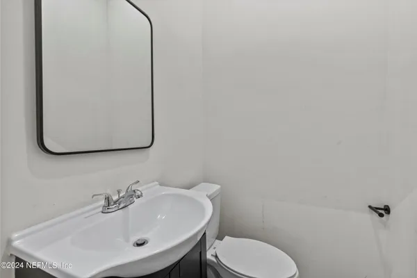 a bathroom with a toilet sink and mirror