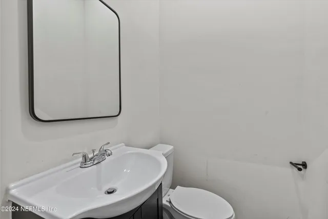a bathroom with a toilet sink and mirror