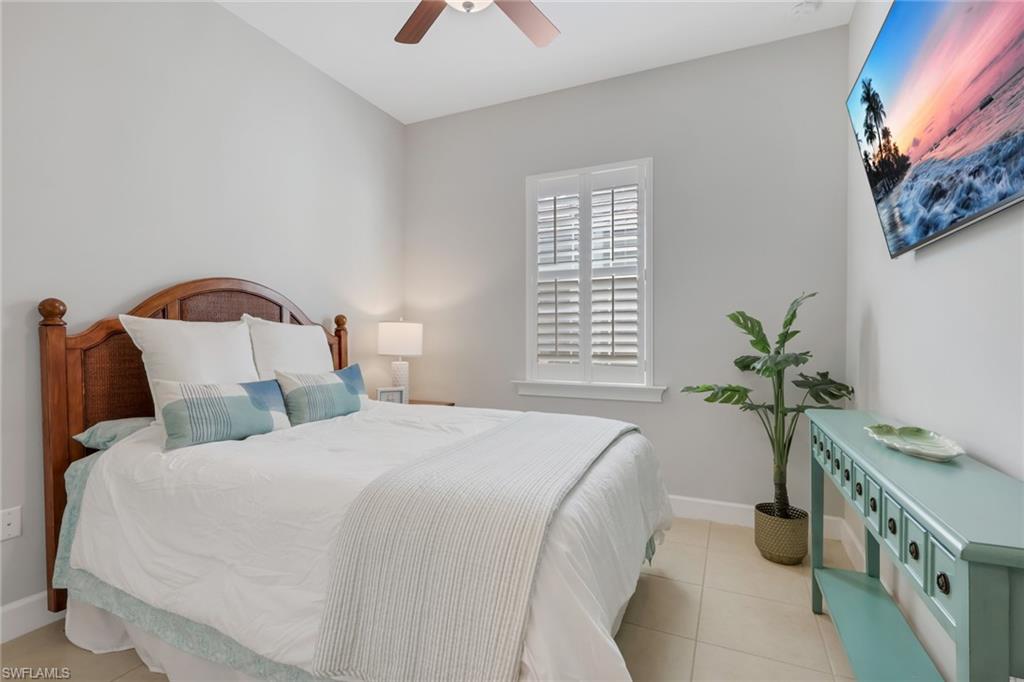 6809 Bequia Way Naples, FL 34113 - Photo 17 of 46 Bedroom with light tile patterned floors and ceiling fan