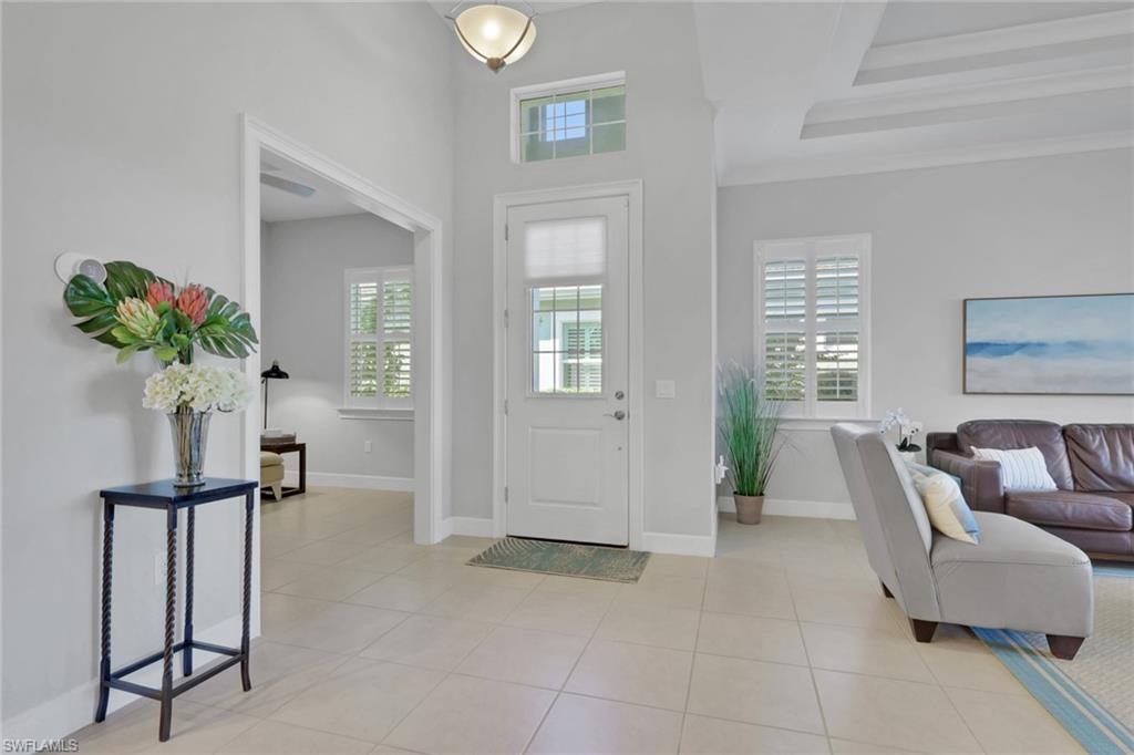 6809 Bequia Way Naples, FL 34113 - Photo 4 of 46 Entrance foyer featuring healthy amount of natural light and light tile patterned floors