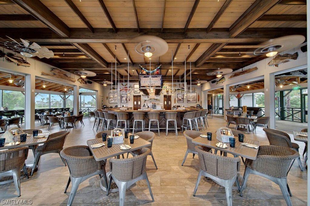 6809 Bequia Way Naples, FL 34113 - Photo 43 of 46 Dining space featuring healthy amount of natural light and a wood ceiling with exposed beams