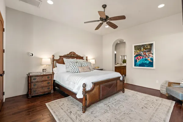 a bedroom with a bed a dresser and painting on the wall