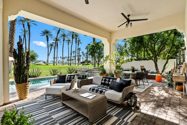 a living room with patio furniture and a potted plant