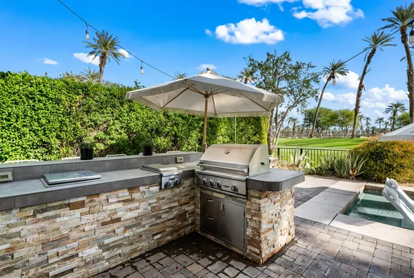 a view of a patio with a table and chairs under an umbrella
