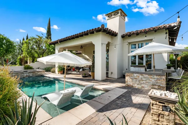 a patio with a table and chairs under an umbrella