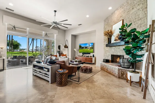 a living room with furniture a fireplace and a potted plant