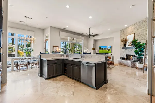a large kitchen with kitchen island a counter top space a sink stainless steel appliances and cabinets