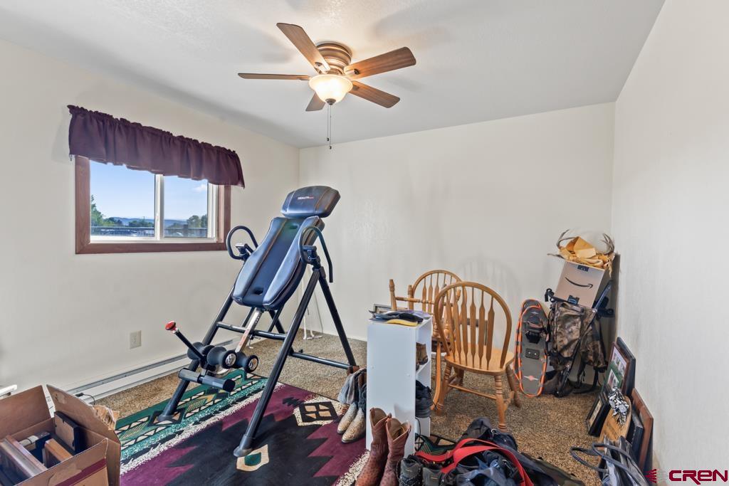 15567 6282nd Road Montrose, CO 81403 - Photo 14 of 36 a view of a workspace with furniture and a ceiling fan