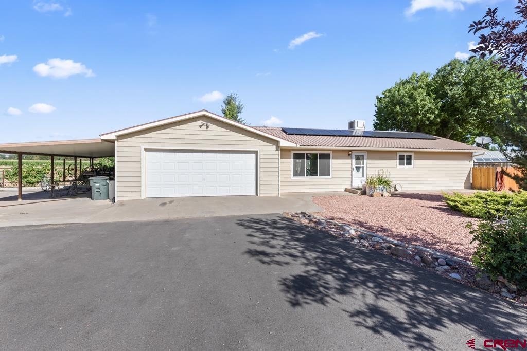 15567 6282nd Road Montrose, CO 81403 - Photo 28 of 36 a front view of a house with a yard and garage