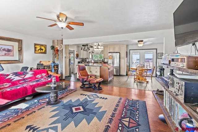 a living room with furniture a flat screen tv and a window