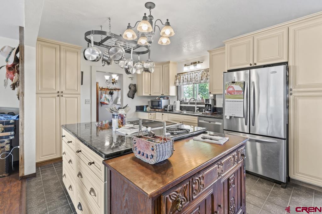15567 6282nd Road Montrose, CO 81403 - Photo 8 of 36 a kitchen with stainless steel appliances granite countertop a refrigerator a sink dishwasher a stove and a dining table with wooden floor