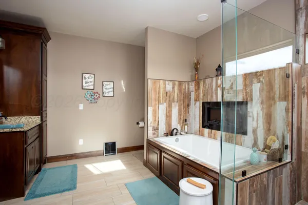 a bathroom with a granite countertop tub sink a mirror and shower