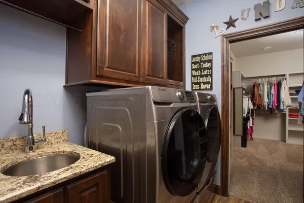 a utility room with sink dryer and washer