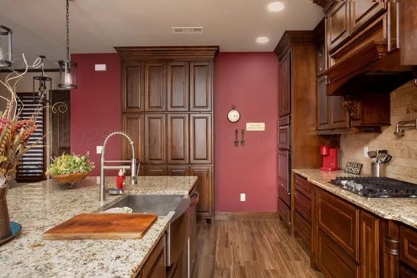 a kitchen with stainless steel appliances granite countertop a sink stove and cabinets