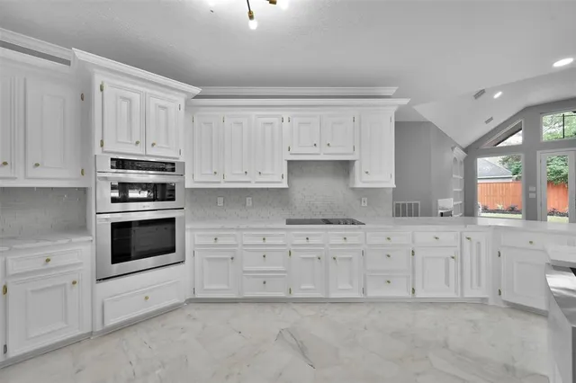 a kitchen with granite countertop white cabinets and white appliances
