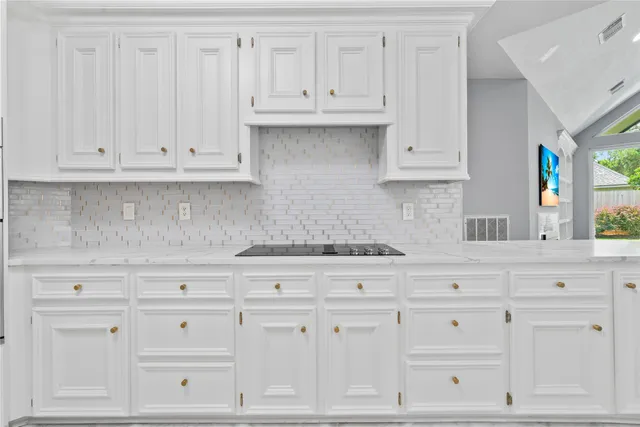 a kitchen with white cabinets and white appliances