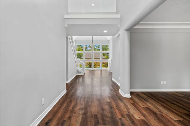a view of a room with wooden floor a ceiling fan and window