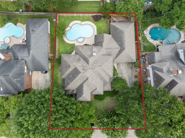an aerial view of a house with outdoor space and a lake view in back
