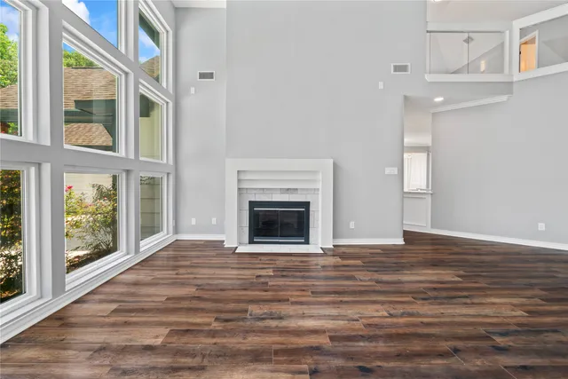 a view of an empty room with glass door and wooden floor