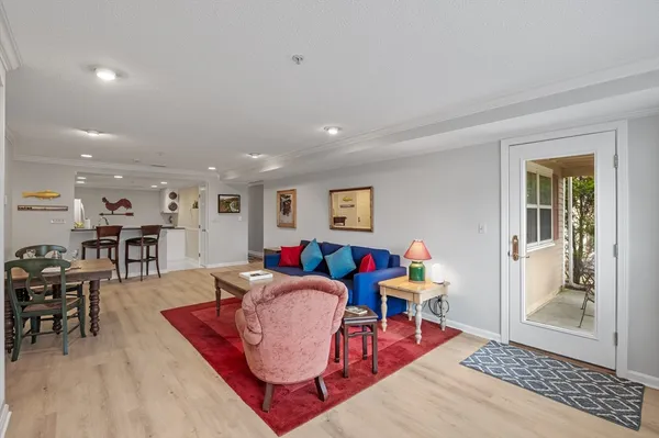 a living room with furniture a table and wooden floor