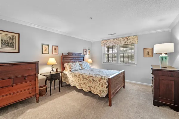 a bedroom with a large bed and a chandelier