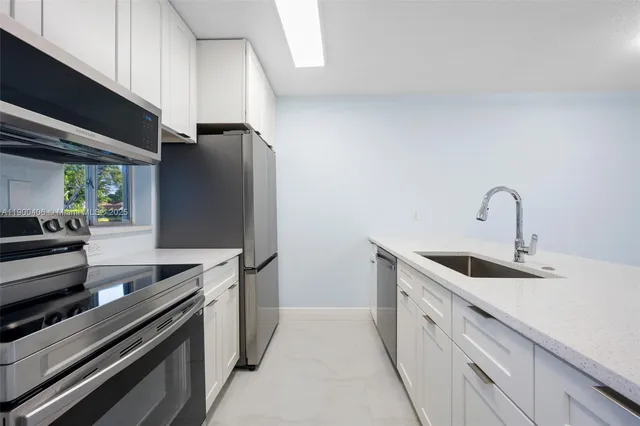a kitchen with stainless steel appliances granite countertop a sink and a stove