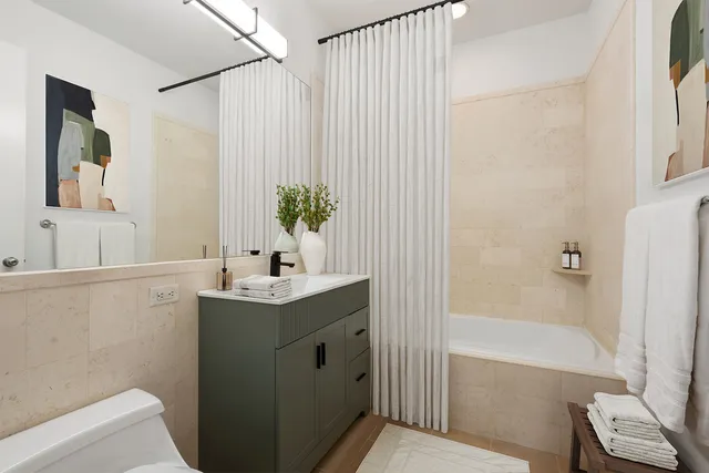 a bathroom with a granite countertop sink a toilet and shower