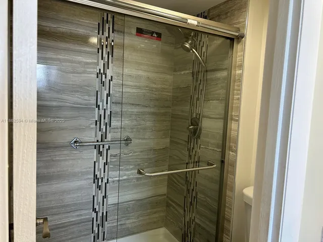 front view of a bathroom with a sink and mirror