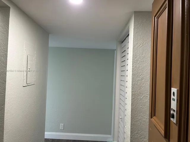 a view of a hallway with wooden shelves
