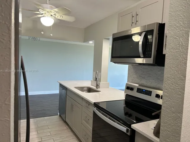 a kitchen with sink and refrigerator