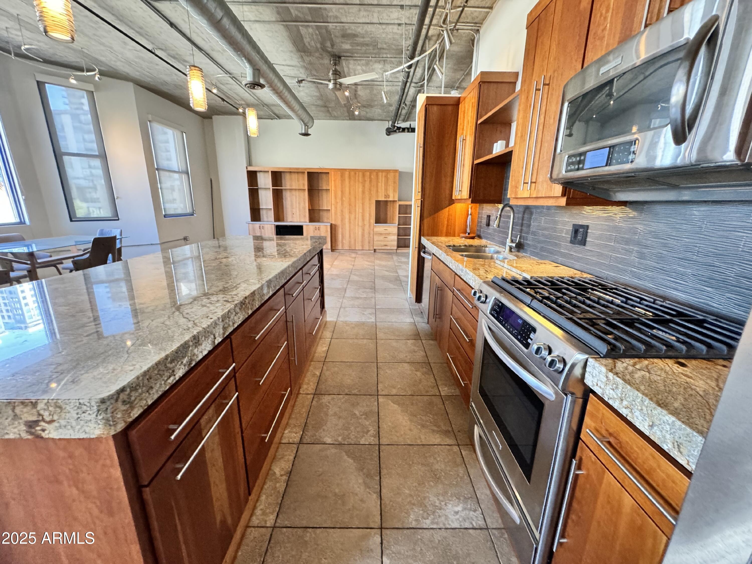 21 East 6th Street, Unit 306 Tempe, AZ 85281 - Photo 11 of 17 a kitchen with stainless steel appliances granite countertop a stove a sink and dishwasher