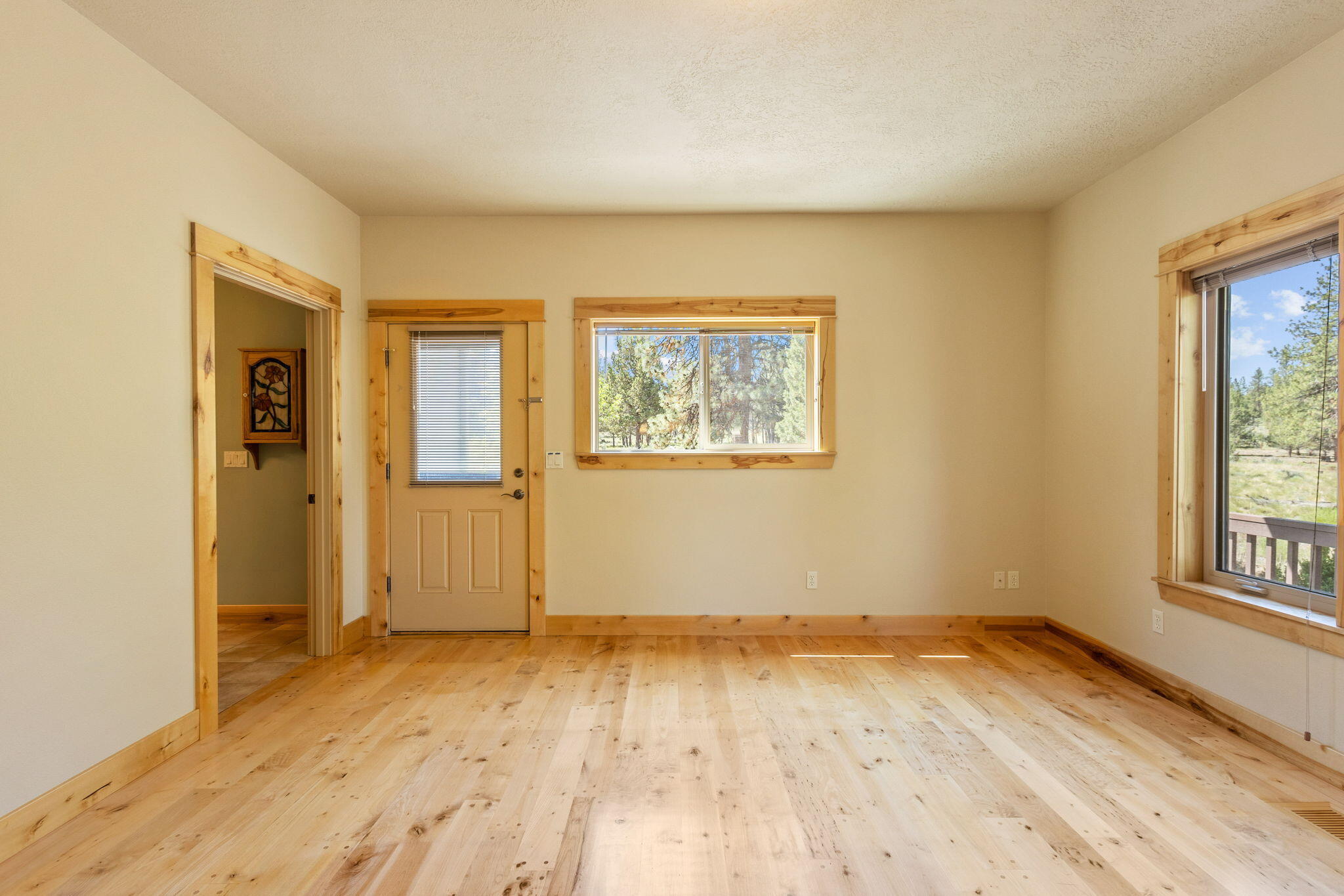 21405 Back Alley Road Bend, OR 97702 - Photo 22 of 48 an empty room with wooden floor and windows