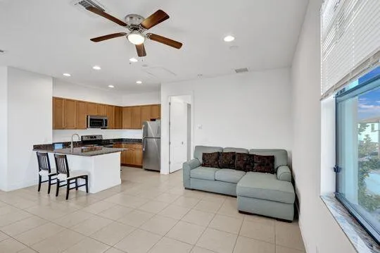 a living room with furniture and kitchen view