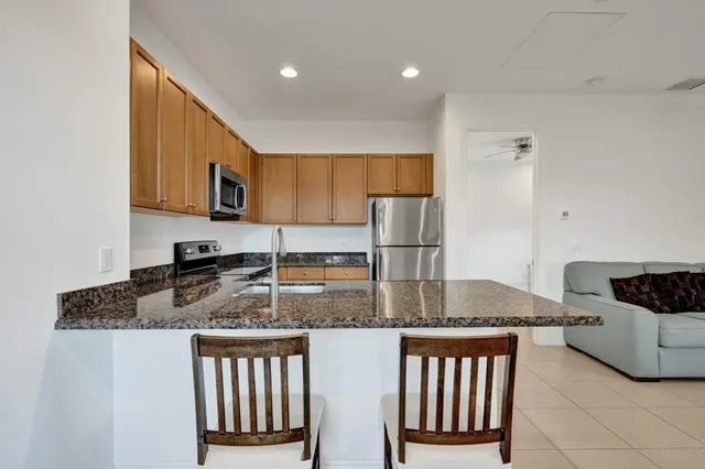 a kitchen with stainless steel appliances granite countertop a sink refrigerator and microwave