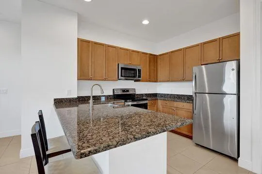 a kitchen with granite countertop a refrigerator and a sink