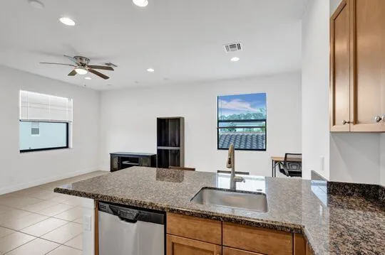 a kitchen with stainless steel appliances granite countertop a sink a refrigerator and a granite counter tops