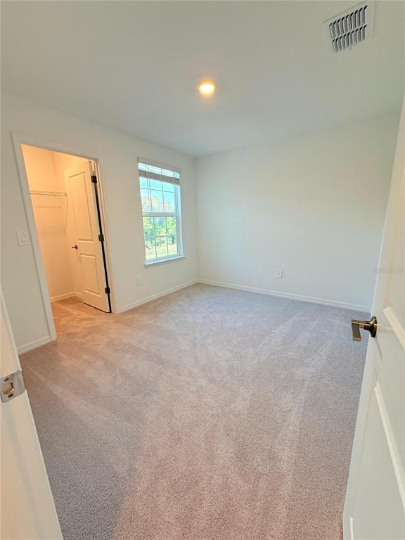 17602 Pleasantview Boulevard Land O Lakes, FL 34638 - Photo 23 of 27 an empty room with windows and closet