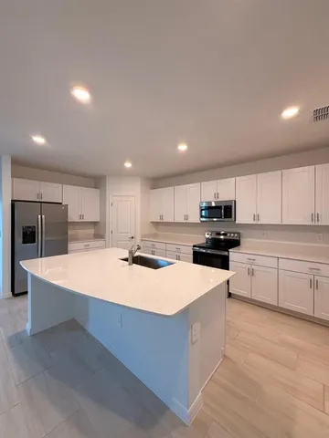 a kitchen with stainless steel appliances kitchen island granite countertop a stove and a sink