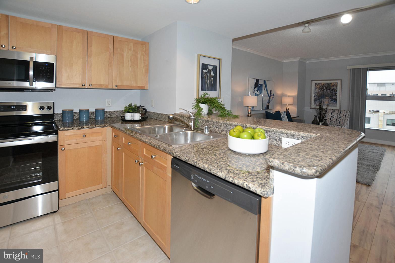 777 7th Street Northwest, Unit 1014 Washington, DC 20001 - Photo 20 of 43 a kitchen with granite countertop stainless steel appliances a stove sink and microwave