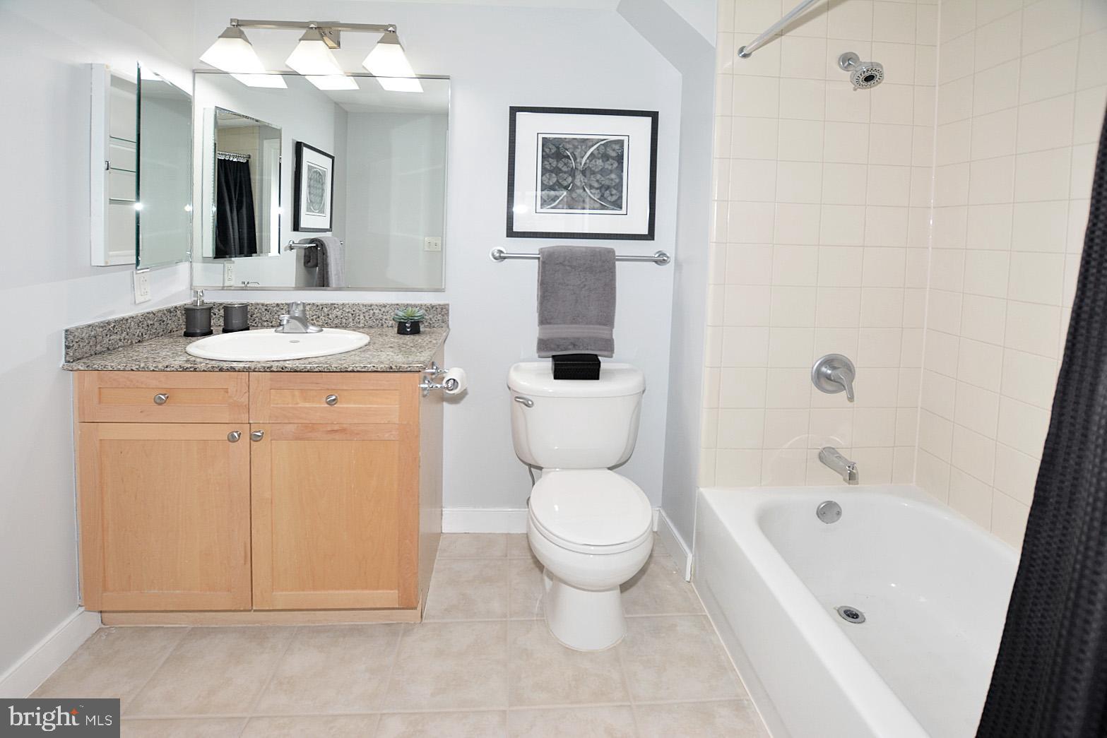 777 7th Street Northwest, Unit 1014 Washington, DC 20001 - Photo 28 of 43 a bathroom with a granite countertop toilet a sink and a bathtub