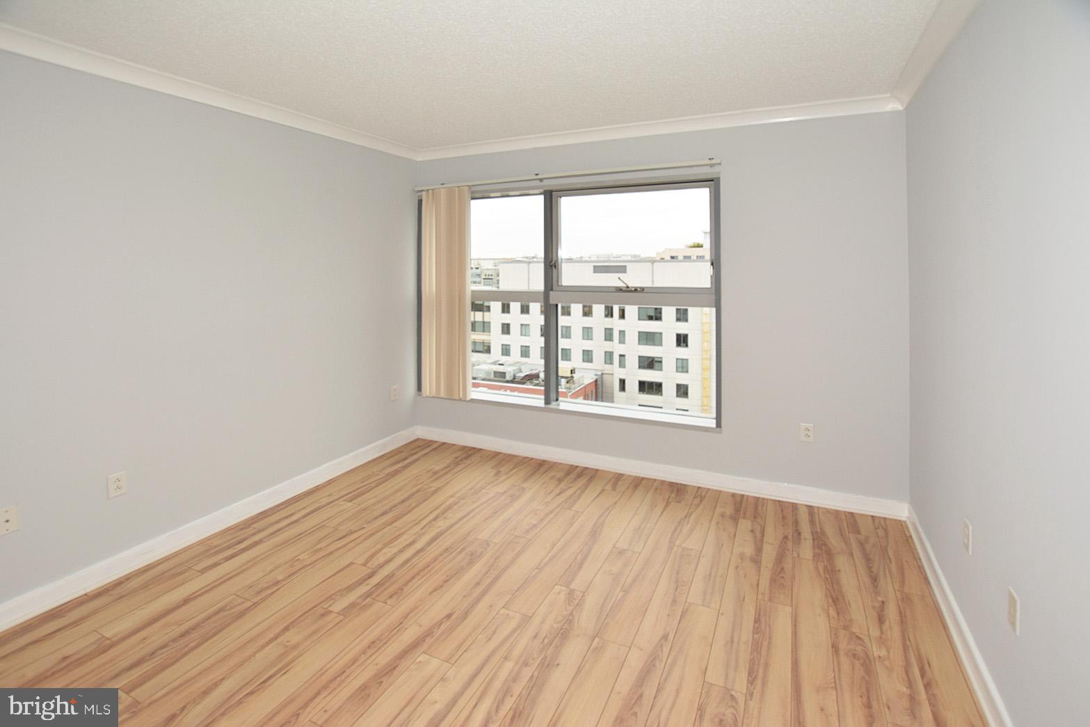 777 7th Street Northwest, Unit 1014 Washington, DC 20001 - Photo 30 of 43 an empty room with wooden floor and windows